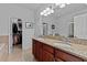 Main bathroom showcasing double sinks with granite countertops and a walk-in closet at 7309 S Shamrock Rd, Tampa, FL 33616