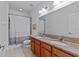 Bathroom featuring dual sinks, granite countertops, and modern fixtures plus a toilet and bath at 7309 S Shamrock Rd, Tampa, FL 33616
