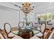 Dining area featuring a decorative chandelier, glass table, and natural light, perfect for entertaining at 7309 S Shamrock Rd, Tampa, FL 33616