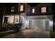 Charming two-story home with manicured lawn, two car garage and inviting blue front door at night at 7309 S Shamrock Rd, Tampa, FL 33616