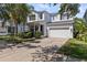 Charming two-story home featuring a well-manicured lawn, bright blue front door, and a two-car garage at 7309 S Shamrock Rd, Tampa, FL 33616