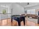 Spacious game room featuring a foosball table, a leather sofa, and hardwood floors at 7309 S Shamrock Rd, Tampa, FL 33616