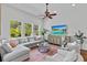 Spacious living room boasts large windows, a ceiling fan, comfortable seating, and modern decor at 7309 S Shamrock Rd, Tampa, FL 33616