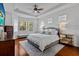 Bright bedroom with a tray ceiling features large windows, a ceiling fan, and modern decor at 7309 S Shamrock Rd, Tampa, FL 33616