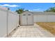 Backyard view showcasing a shed, white fence, concrete tile path, and well-maintained exterior creating private storage at 8010 Chickasaw Ln, Port Richey, FL 34668