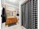 Bathroom with a wood vanity and a shower with a checked shower curtain at 8010 Chickasaw Ln, Port Richey, FL 34668