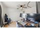 Bright bedroom features a ceiling fan, hardwood floors, two monitors, and a window allowing for natural light at 8010 Chickasaw Ln, Port Richey, FL 34668