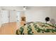Bedroom with wood-look floors, fireplace, ceiling fan and a queen-size bed with views to the bathroom at 8010 Chickasaw Ln, Port Richey, FL 34668