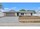 Charming single-story home featuring a well-maintained lawn, stone accents, and an attached garage at 8010 Chickasaw Ln, Port Richey, FL 34668