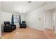 Bright living room with wood floors, two dark comfortable chairs, a ceiling fan, and a bright window at 8010 Chickasaw Ln, Port Richey, FL 34668