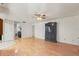 Open living room with wood floors, a ceiling fan, and an antique cabinet at 8010 Chickasaw Ln, Port Richey, FL 34668
