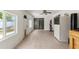 Sun room with tile floors, white walls, ceiling fan, sliding glass door, and pet door provides a versatile space at 8010 Chickasaw Ln, Port Richey, FL 34668