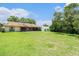 Spacious backyard features a well-manicured lawn and a view of the home's exterior at 8105 Valley Stream Ln, Hudson, FL 34667