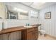 Vintage bathroom featuring laminate countertops, patterned wall paper, tile flooring, and a large mirror at 8105 Valley Stream Ln, Hudson, FL 34667