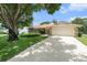Charming single Gathering home with stone accents, a large driveway, mature trees, and a well maintained lawn at 8105 Valley Stream Ln, Hudson, FL 34667