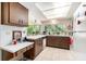 Well-lit kitchen with laminate countertops, ample cabinet space, and large bright windows at 8105 Valley Stream Ln, Hudson, FL 34667