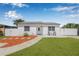 Charming single-story home with freshly manicured lawn, inviting entryway, and white picket fence at 812 60Th S St, Gulfport, FL 33707