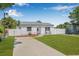 Charming single-story home featuring manicured lawn, fresh driveway, inviting entryway, and white picket fence at 812 60Th S St, Gulfport, FL 33707