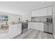Bright kitchen features stainless appliances, granite counters, white cabinets, and wood-look floors at 812 60Th S St, Gulfport, FL 33707