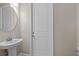 Compact powder room featuring a pedestal sink and a round mirror with neutral wall paint at 8264 Dafoe St, Port Charlotte, FL 33981