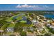 Aerial view of a house beside a pond, golf course, and upscale homes in a mature and lush neighborhood at 852 Cordova Ne Blvd, St Petersburg, FL 33704