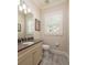Well-lit half bath with tile floors, a modern vanity with dark countertops, and a window with shutters at 852 Cordova Ne Blvd, St Petersburg, FL 33704