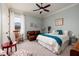 Spacious bedroom with a vintage rocking chair, a soft brown couch, and natural light from the window at 852 Cordova Ne Blvd, St Petersburg, FL 33704