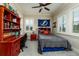 Cozy bedroom with a red wooden desk, built-in shelves, a bed and plenty of natural light at 852 Cordova Ne Blvd, St Petersburg, FL 33704