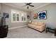 Comfortable bedroom with neutral walls, ceiling fan, a cozy couch, and natural light from the window at 852 Cordova Ne Blvd, St Petersburg, FL 33704