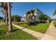 Landscaped lawn with mature trees and manicured garden beds surrounding this inviting two-story home at 852 Cordova Ne Blvd, St Petersburg, FL 33704