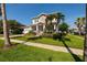 Well-maintained yard with lush green grass, stately palms, and meticulous landscaping adds charm to the facade at 852 Cordova Ne Blvd, St Petersburg, FL 33704