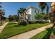 The exterior of this home includes a beautiful manicured lawn and garden with a sidewalk, shrubs, and trees at 852 Cordova Ne Blvd, St Petersburg, FL 33704