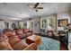 Inviting living room with a comfortable leather sectional, cozy seating, and an open view to the kitchen at 852 Cordova Ne Blvd, St Petersburg, FL 33704