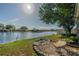 The backyard boasts a beautiful lake view with a garden and stone bench at 913 El Rancho Dr, Sun City Center, FL 33573