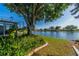 A well-manicured lawn and garden area with lake views provide a relaxing place in the backyard at 913 El Rancho Dr, Sun City Center, FL 33573