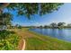 A well-manicured lawn and garden area with lake views provide a relaxing place in the backyard at 913 El Rancho Dr, Sun City Center, FL 33573
