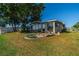 A well-manicured lawn and garden area provide a relaxing view of the enclosed back porch at 913 El Rancho Dr, Sun City Center, FL 33573