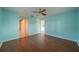 Bedroom featuring bright blue walls, wood flooring and a ceiling fan at 913 El Rancho Dr, Sun City Center, FL 33573