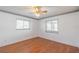 Well-lit bedroom with hardwood flooring and two windows at 913 El Rancho Dr, Sun City Center, FL 33573