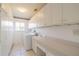 Bright laundry room featuring ample cabinet space, utility sink, and modern washer and dryer at 913 El Rancho Dr, Sun City Center, FL 33573