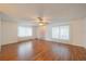 Bright living room with hardwood floors, ceiling fan, and sheer curtains providing natural light at 913 El Rancho Dr, Sun City Center, FL 33573