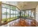 Glass enclosed sunroom with views of the lake and a ceiling fan at 913 El Rancho Dr, Sun City Center, FL 33573