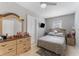 Cozy bedroom featuring a ceiling fan, TV, and a matching dresser with a large decorative mirror at 918 E 24Th Ave, Tampa, FL 33605