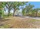 Spacious front yard with mature trees, a well-kept lawn, and a view of the charming single-story home at 918 E 24Th Ave, Tampa, FL 33605