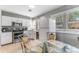 Bright kitchen with white cabinets, stainless steel appliances, tile flooring, and a dining table at 918 E 24Th Ave, Tampa, FL 33605