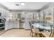 Bright kitchen with white cabinets, stainless steel appliances, tile flooring, and a dining table at 918 E 24Th Ave, Tampa, FL 33605