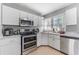 Bright kitchen with white cabinets, stainless steel appliances, tile flooring, and a large window at 918 E 24Th Ave, Tampa, FL 33605