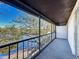Water view from screened balcony with railing, overlooking mature trees and a lake at 9201 Tudor Dr # C212, Tampa, FL 33615