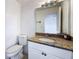 Bathroom featuring a white vanity with a granite countertop and a matching white toilet at 9201 Tudor Dr # C212, Tampa, FL 33615