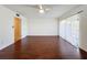 Large bedroom featuring hardwood floors, a ceiling fan, and sliding glass doors at 9201 Tudor Dr # C212, Tampa, FL 33615